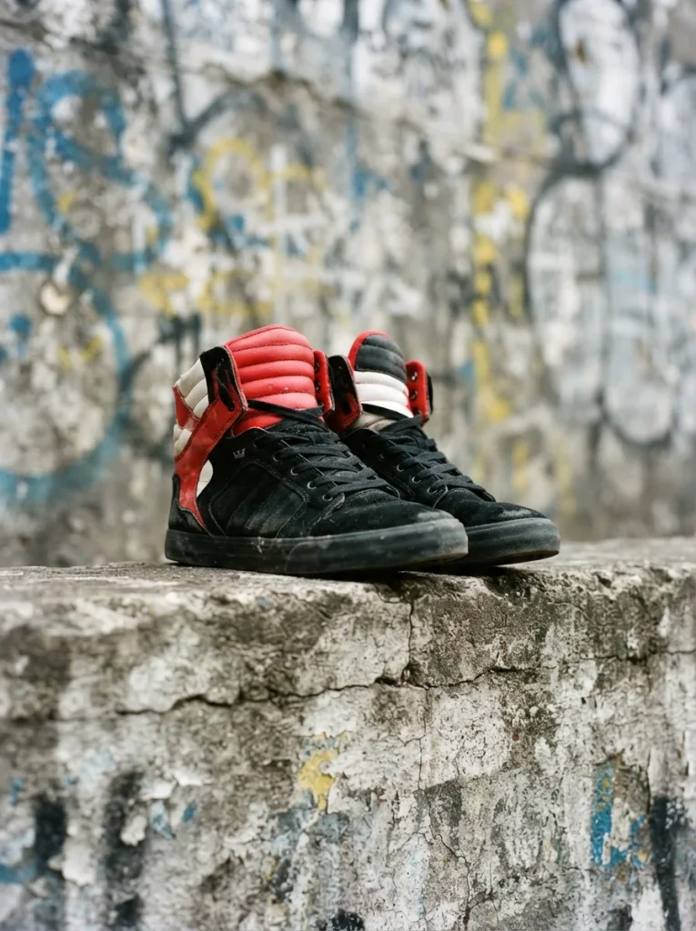 Supra Skytop 2 high-top sneakers arranged on a graffiti-covered urban wall, showcasing vibrant colors.